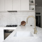 Unique Faucet Designs for a Luxury Kitchen Sink a modern kitchen, focused on the kitchen sink with a brass faucet