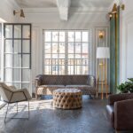 A chic, luxurious living room design with old-fashioned antique furniture, white walls, and modern gold accent decor.