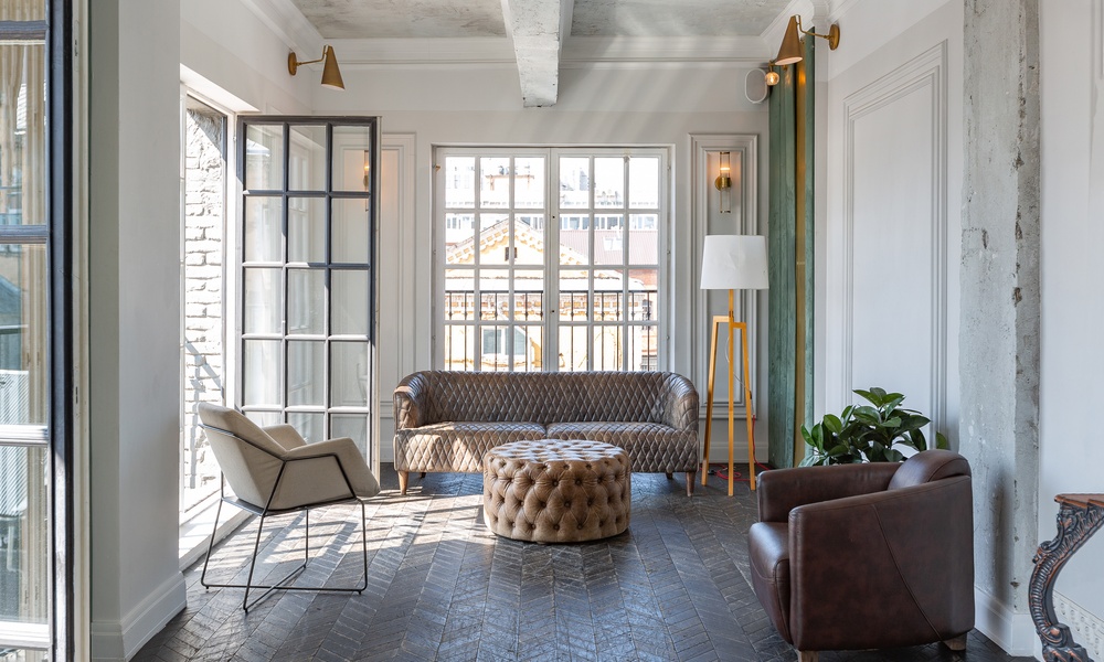A chic, luxurious living room design with old-fashioned antique furniture, white walls, and modern gold accent decor.
