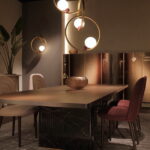 A dining room area with luxurious light fixtures. The lights are dimmed, and the space is decorated with gold accents.