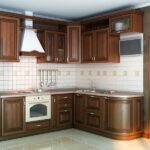 A newly remodeled kitchen with dark wooden cabinets, a tiled backsplash, a wall-mounted TV, and shiny flooring.